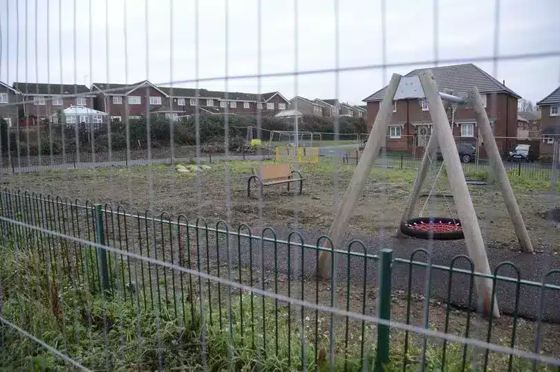 Half-finished playground left fenced off in the middle of a newly built Cardiff housing estate.jpg